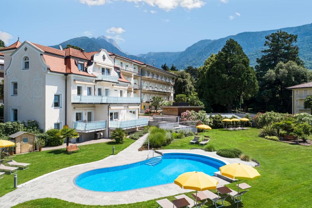 梅拉诺菲力品诺姆酒店的一座带游泳池和遮阳伞的度假村的图片