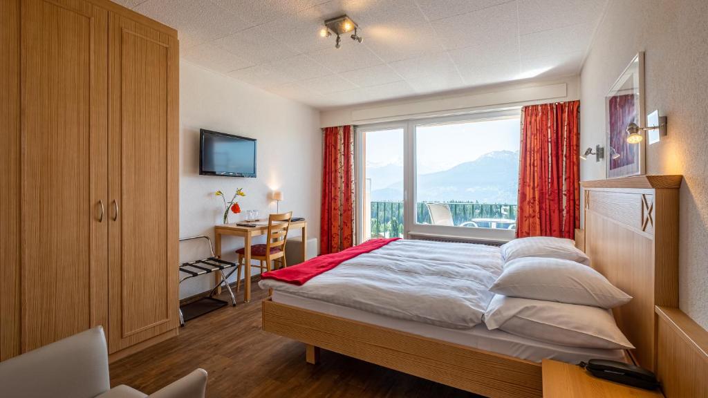 克莱恩 蒙塔纳斯普莱迪德酒店的一间卧室设有一张大床和大窗户