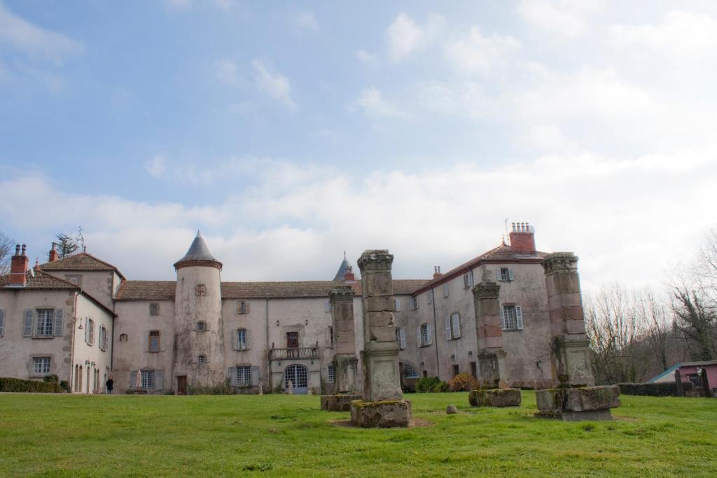 Olliergues尚特劳兹城堡酒店的一座古老的城堡,前面有草地