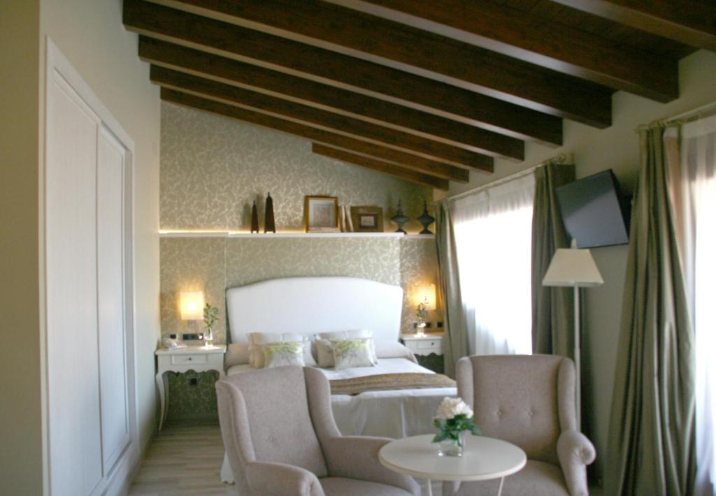 阿尔克萨尔Hotel Castillo的一间卧室配有一张床、两把椅子和一张桌子