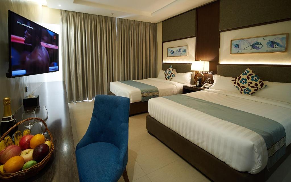 伊洛伊洛J7 Plaza Hotel的酒店客房带两张床和一碗水果