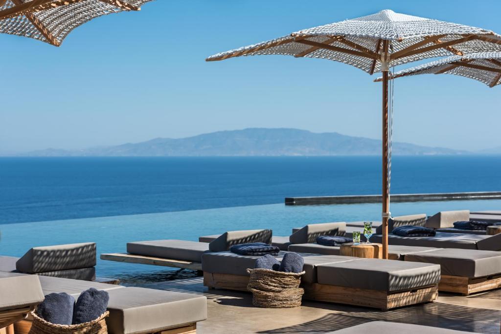 伊亚Andronis Arcadia Hotel的一把带遮阳伞和海洋的躺椅
