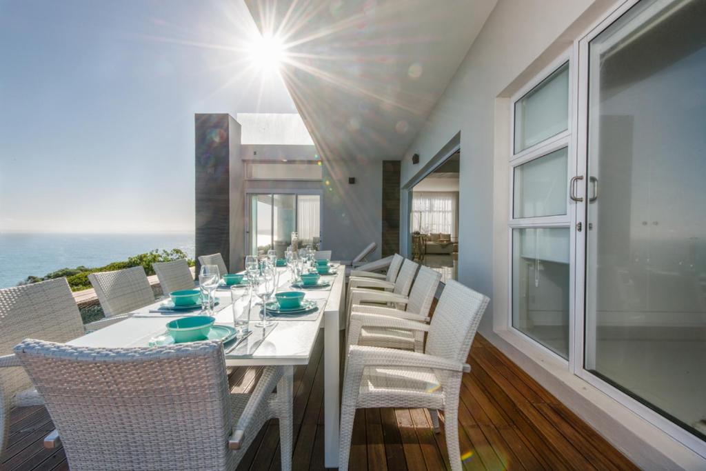 莫塞尔湾Leisure and Golf Retreat Villa Pinnacle Point的一间配备有白色桌椅的用餐室