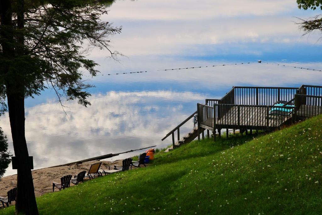 Otter Lake阳光角度假村有限公司的一群长椅坐在俯瞰水面的小山上