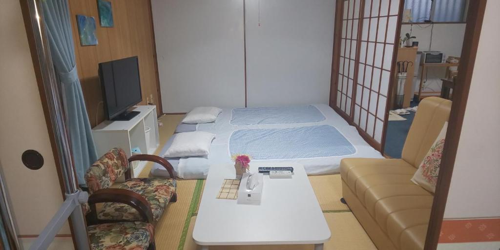 那霸Miyagi Apartment Tomari的配有床、桌子和沙发的房间