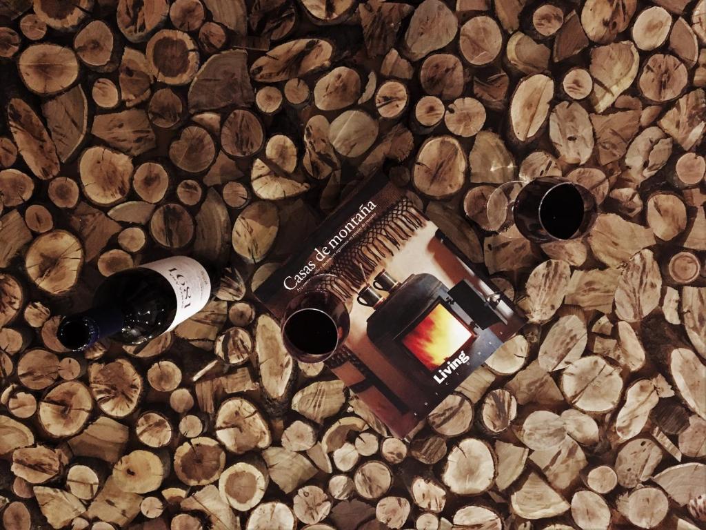 门多萨Como en casa... en gran Mendoza的一堆木头上的一瓶葡萄酒