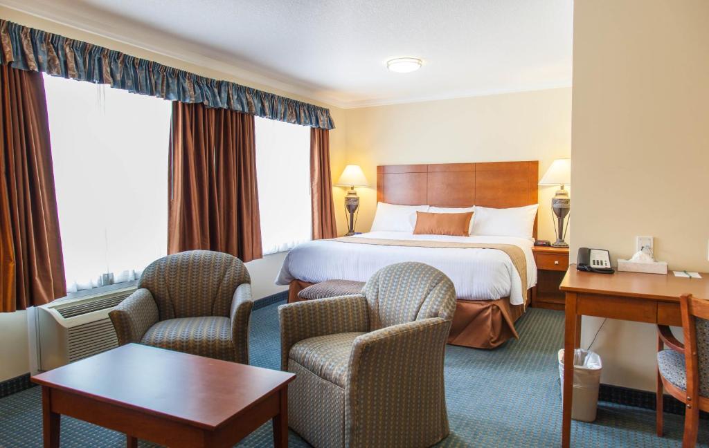 欣顿Hinton Lodge的酒店客房,配有一张床和两把椅子