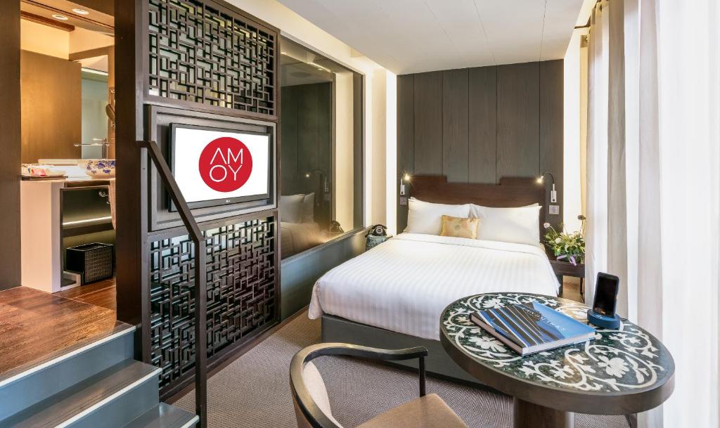 新加坡AMOY by Far East Hospitality的酒店客房设有床、桌子和电视。