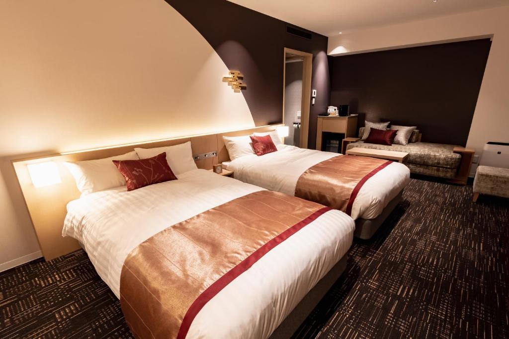金泽金泽酒店的酒店客房,设有两张床和一张沙发