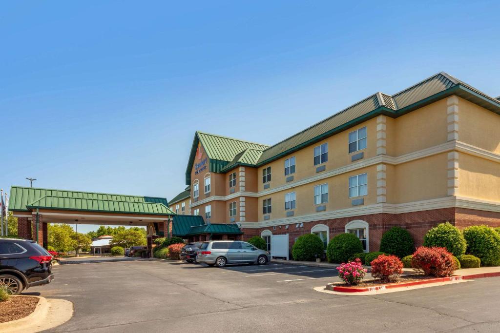 费耶特维尔Comfort Inn & Suites Fayetteville-University Area的停车场内有车辆的旅馆