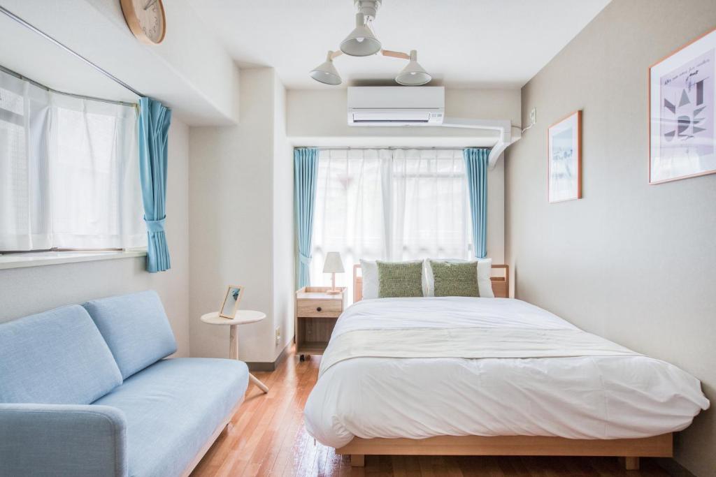 东京Park Residence Omori的一间卧室配有一张床和一张沙发