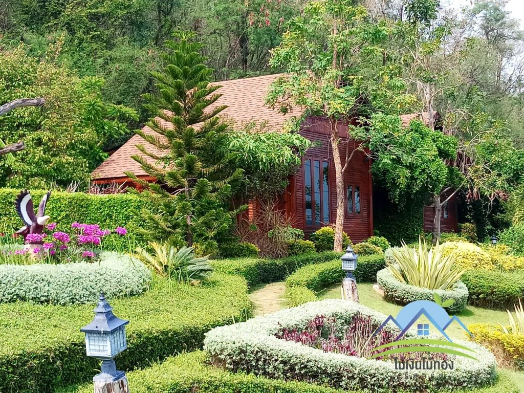 北标府Maingern Maithong Resort的鲜花和植物房子前面的花园