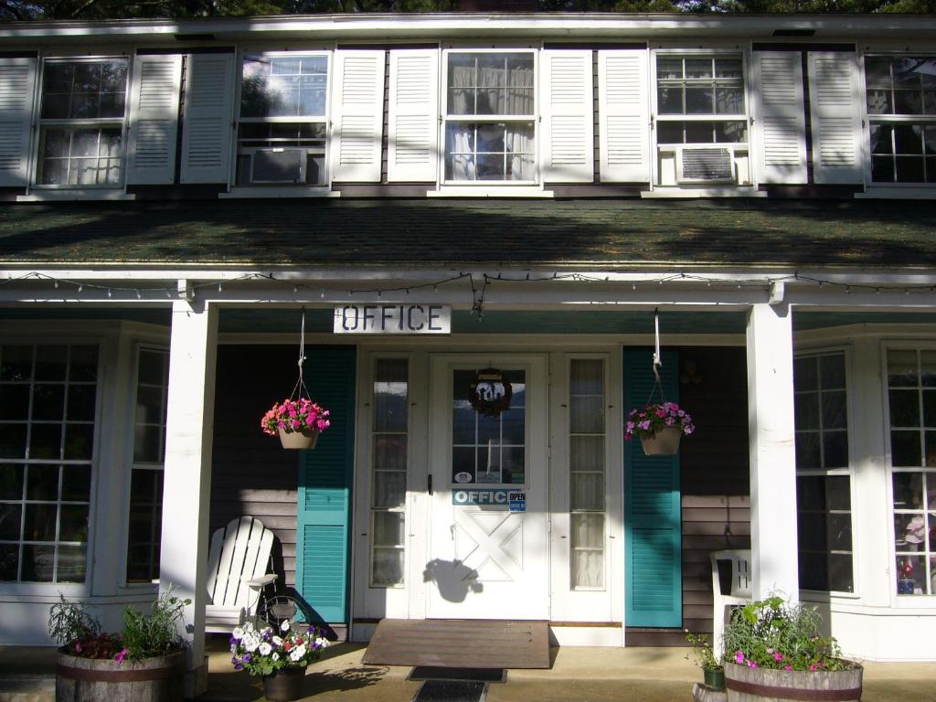 北康威白色特里斯汽车旅馆的一座带蓝色和白色门及鲜花的旧房子