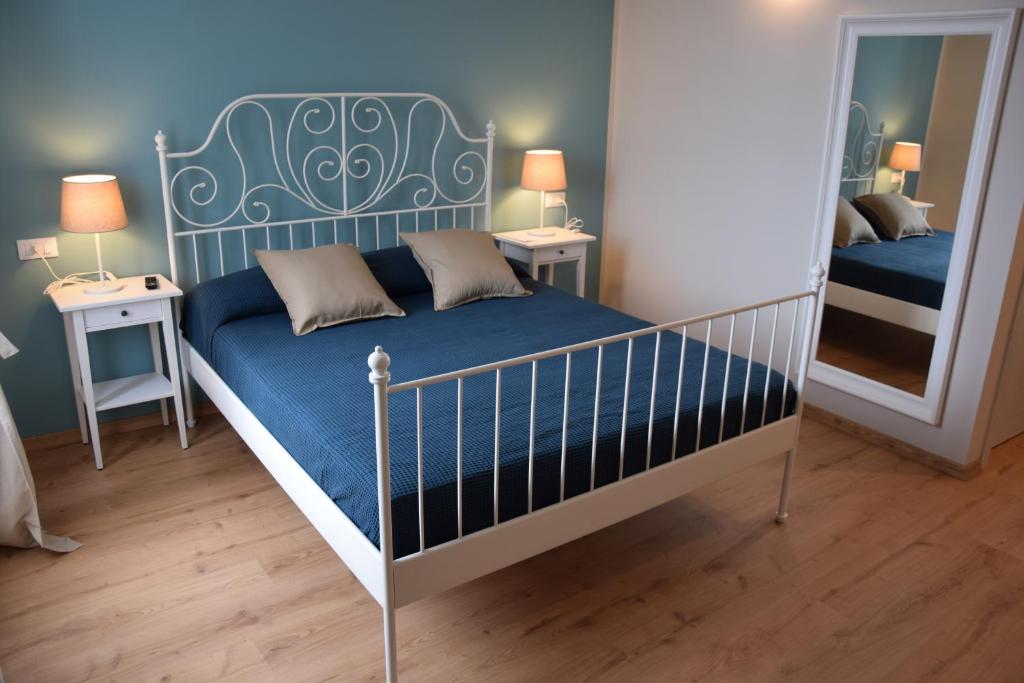 迪亚诺马里纳Le camere della Nonna的一间卧室配有一张带蓝色床垫和镜子的床