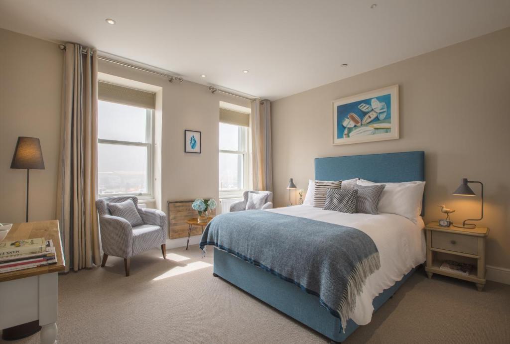 道格拉斯Sail Lofts的一间卧室配有蓝色的床和椅子