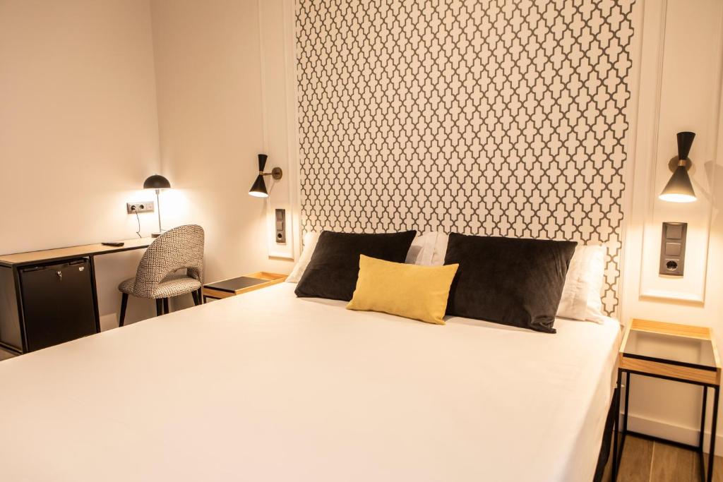 瓦伦西亚Blanq Comedias的卧室配有白色的床和两个枕头