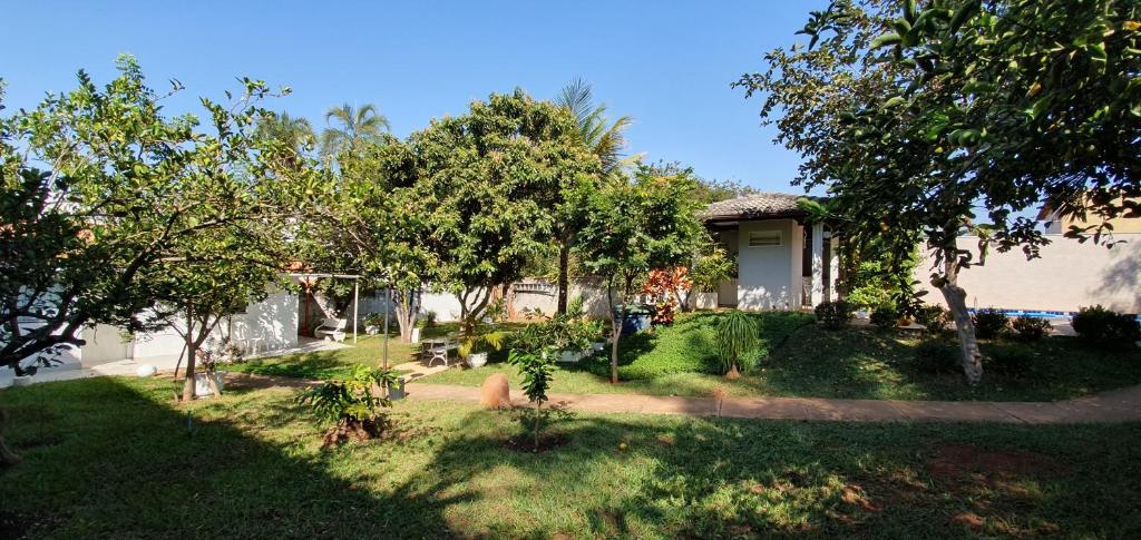 巴西利亚Alt House Qi 02 Lago Norte的一座有树木和草地的院子的房子