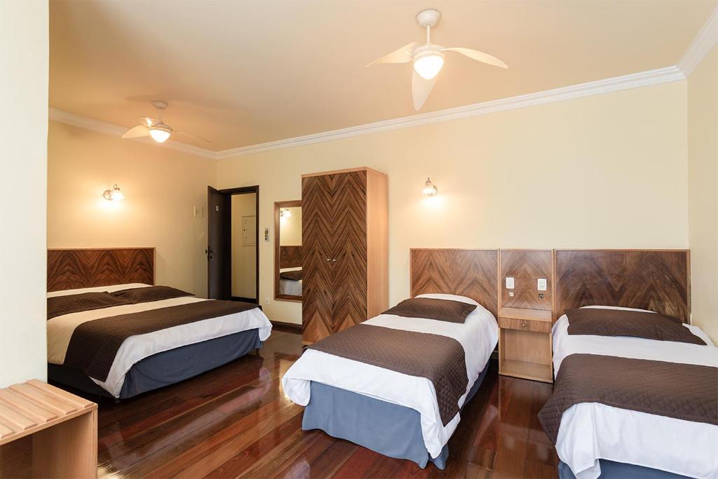 欧鲁普雷图博洛尼皇宫酒店的酒店客房配有两张床和吊扇。