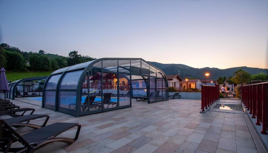 Saint-Martin-dʼArrossaDomaine Chalets Larlapean的一座玻璃温室,位于一个山地庭院内