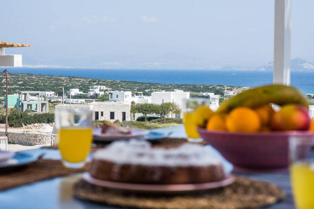 帕罗斯岛Parian Philoxenia Villa, Santa Maria Beach的一张桌子,上面放着一碗水果和一杯橙汁