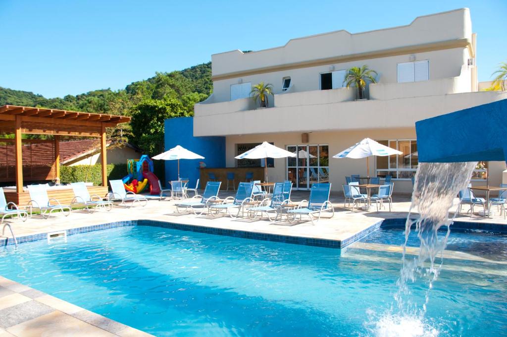 博西坎加阿缇娜普拉亚酒店的一座大楼前的游泳池,带喷泉
