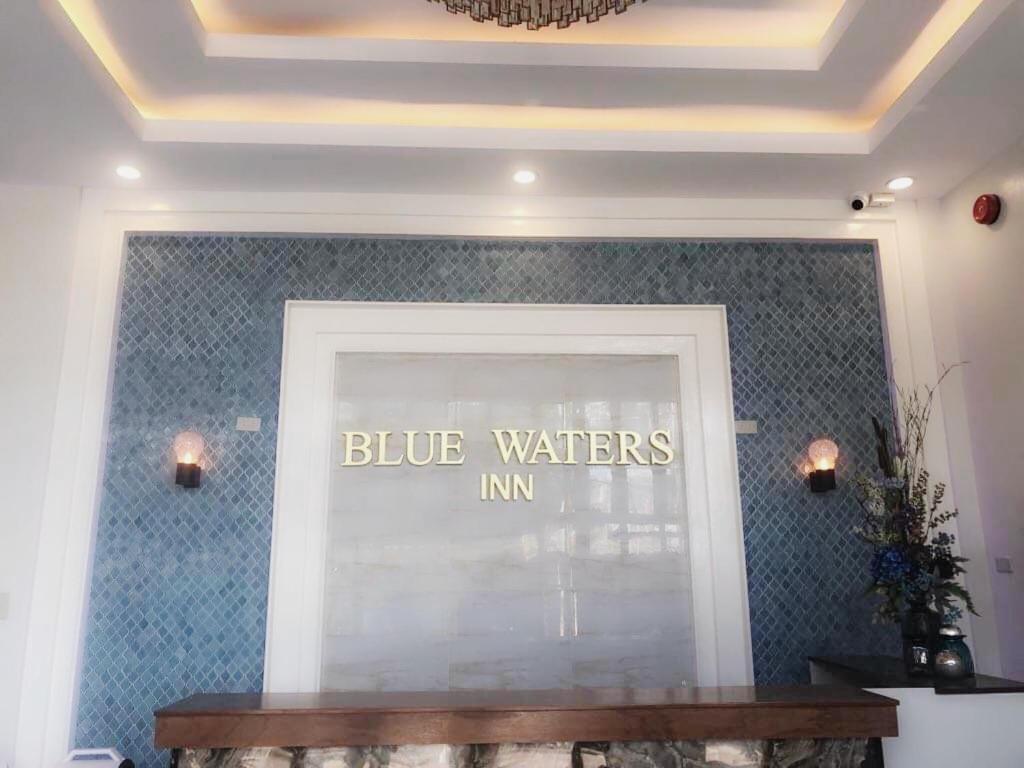 科隆Blue Waters Inn Coron Palawan的上面有蓝色水面标志的商店窗口