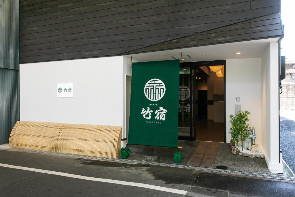 大阪Hostel Takeyado的建筑物一侧的绿色标志