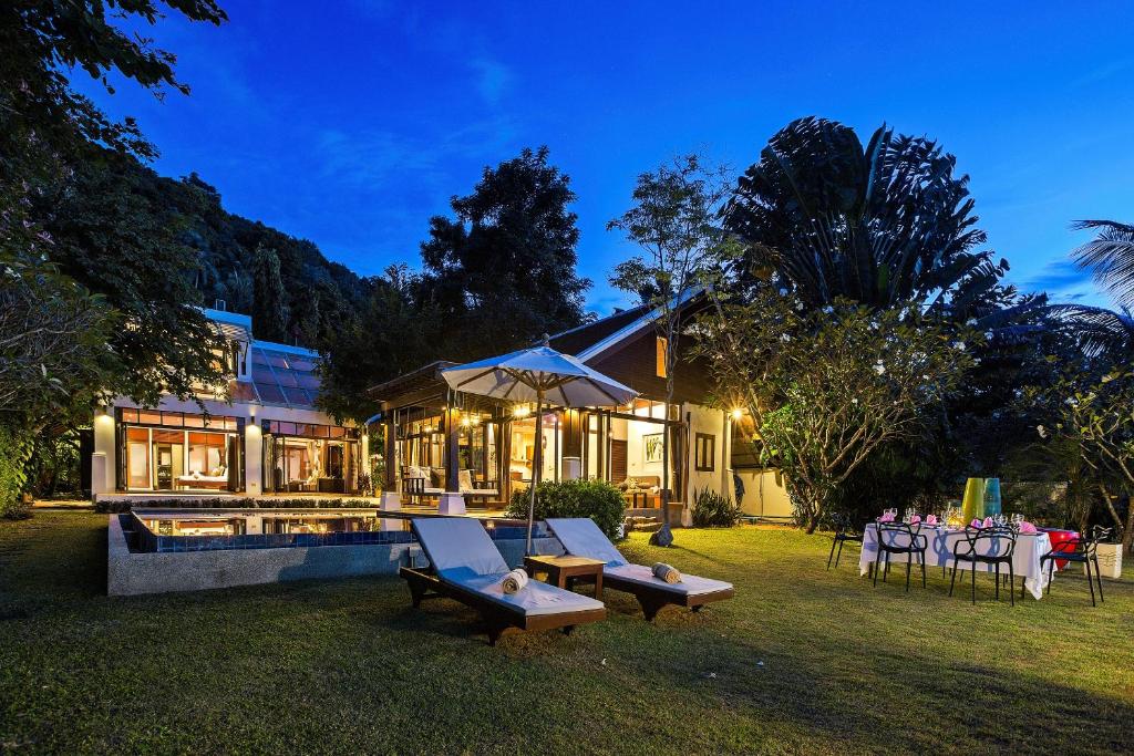 湄南海滩The Emerald Hill Beach Villa的一个带游泳池和桌子的后院