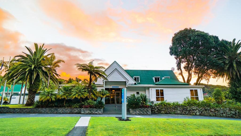 派西亚群岛海湾景区酒店的白色的房子,有绿色的屋顶和棕榈树