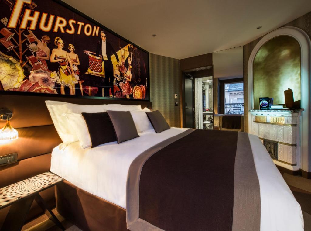 巴黎艾丽赛金碧酒店的卧室配有一张大床,墙上挂着一张海报