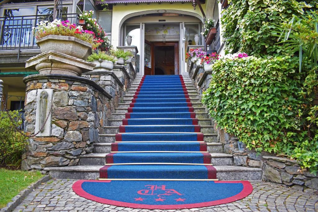 科利科康卡阿祖拉阿尔伯格餐厅酒店的房屋前方有蓝色和红色地毯的楼梯