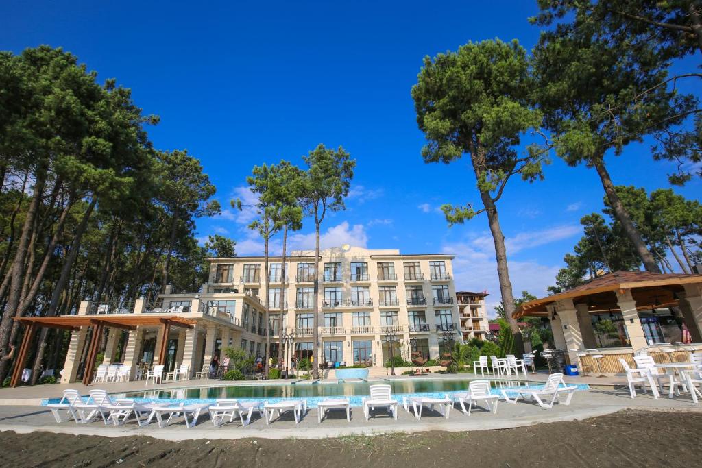 谢赫维蒂利Black Sea Riviera Hotel的一座建筑前的带椅子和游泳池的酒店