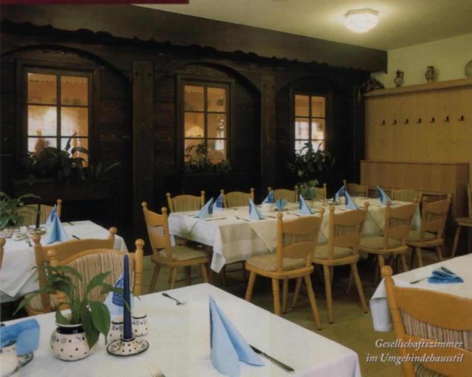 大舍瑙Rübezahlbaude的一间配备有桌椅及蓝餐巾的用餐室