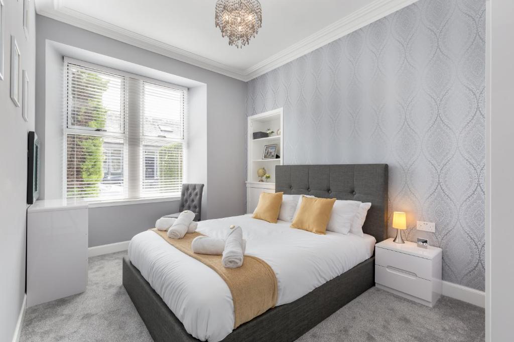 邓弗姆林No 46 - by StayDunfermline的卧室配有一张带白色和橙色枕头的大床