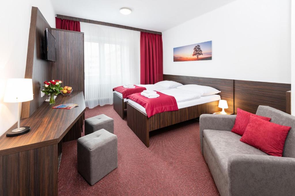 布拉迪斯拉发普乐斯酒店的酒店客房,配有床和沙发