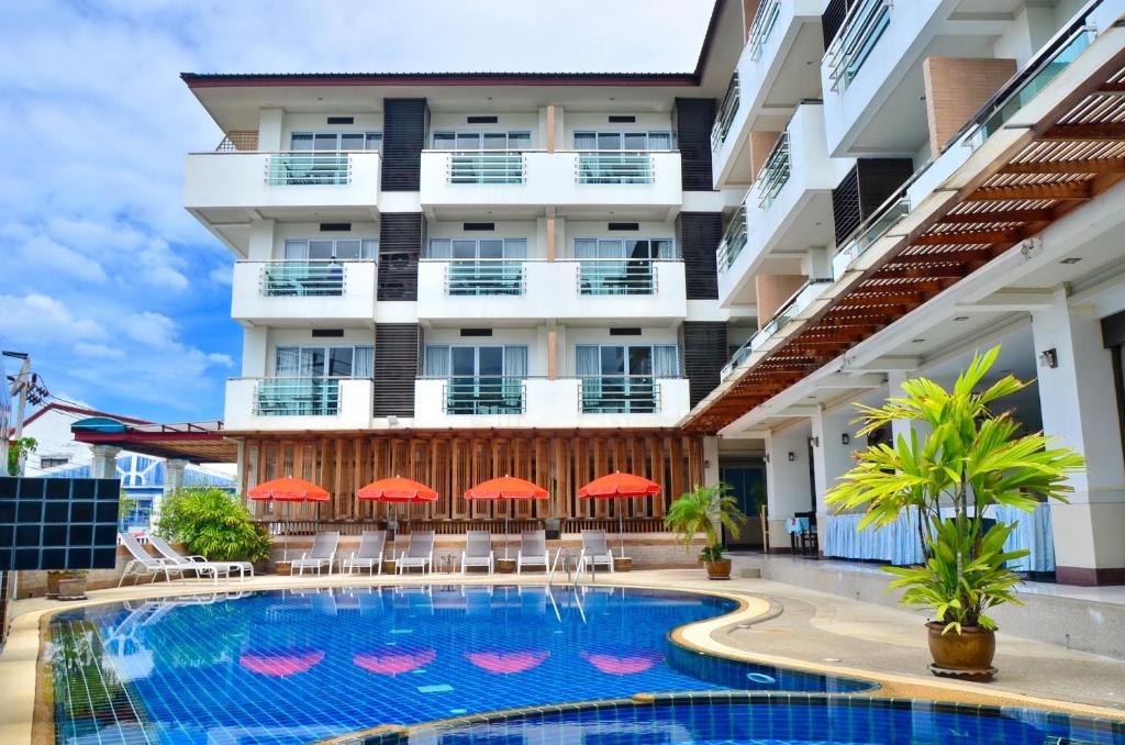 查汶First Residence Hotel的大楼前设有游泳池的酒店