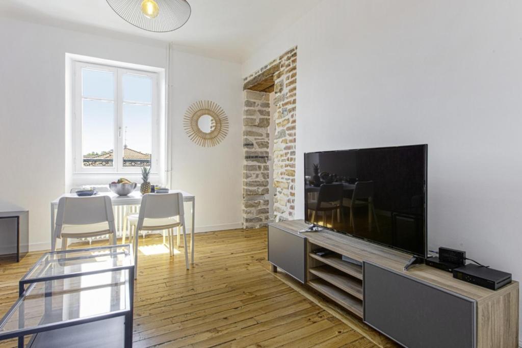 巴约讷Large apartment on Bayonne city-center - Welkeys的客厅配有平面电视和桌子。