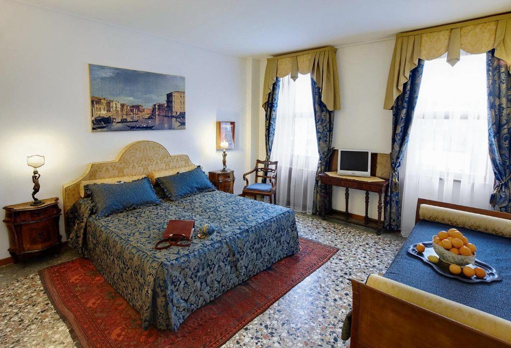 威尼斯卡安杰利酒店的一间卧室配有一张床和一张带果盘的桌子
