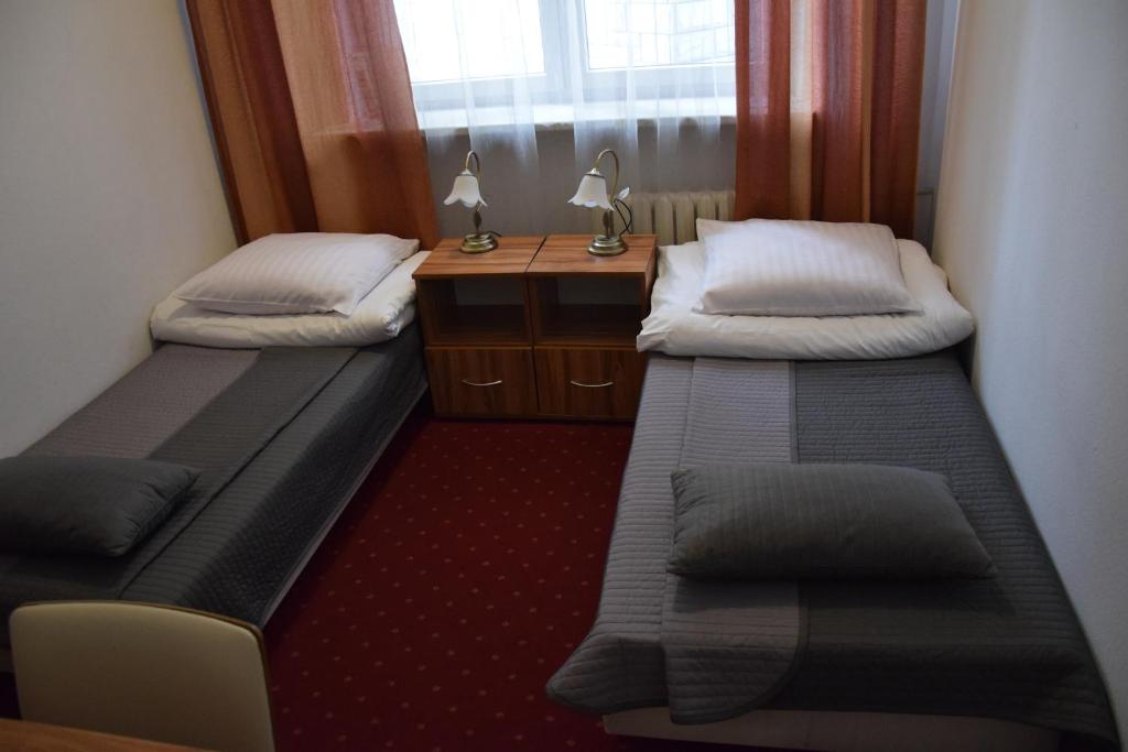 华沙IBIB PAN会议中心旅馆的小房间设有两张床和一张书桌
