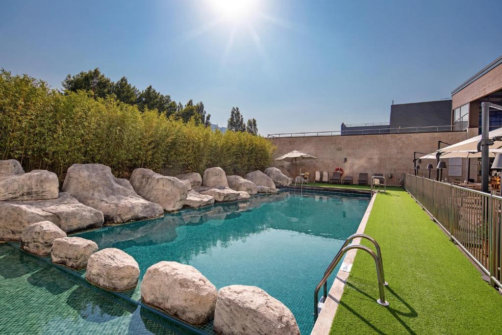 巴拉卡毕尔巴鄂门酒店的庭院内一座带岩石的游泳池