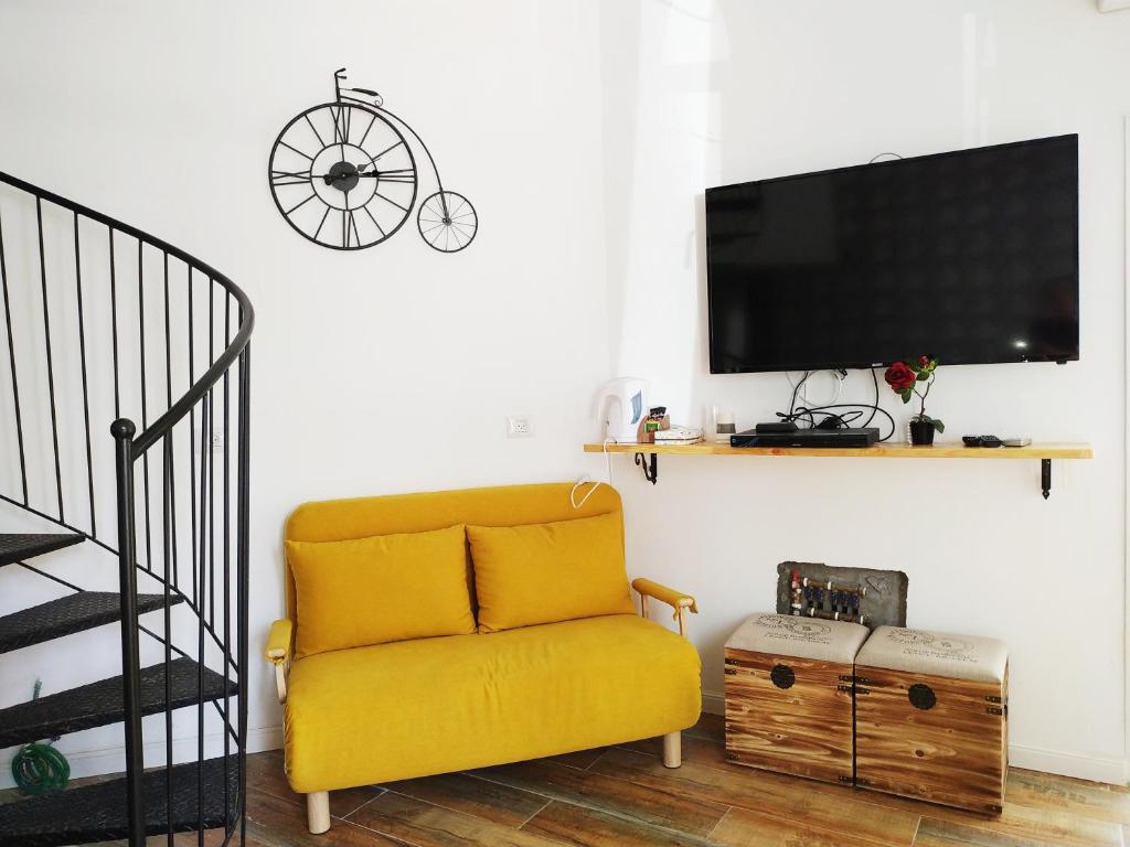 特拉维夫Cohen's Jaffa Rooms的客厅设有黄色沙发和电视