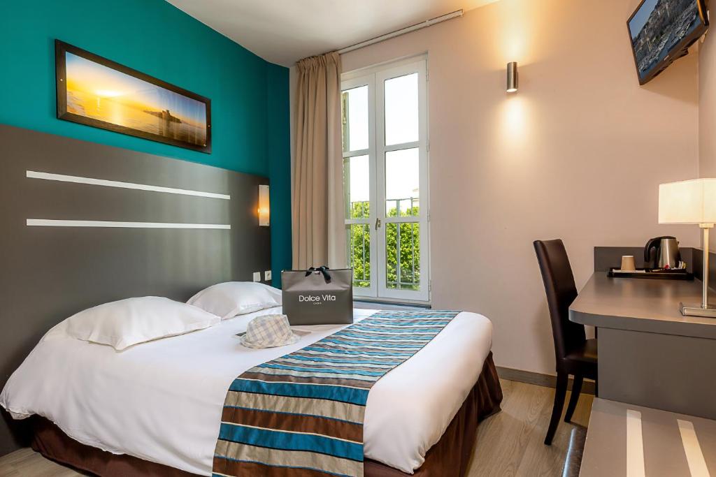 马赛圣查尔斯终点酒店的配有一张床、一张书桌和一扇窗户的酒店客房