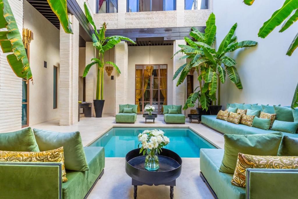 马拉喀什Riad Tajania的一间带游泳池和家具的客厅