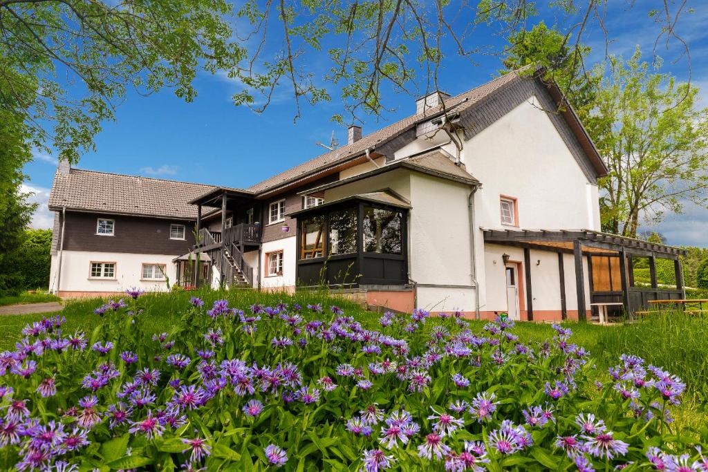 黑伦塔尔Landhaus Schnorrenberg, Wellness & Nature的前面有紫色花的房屋