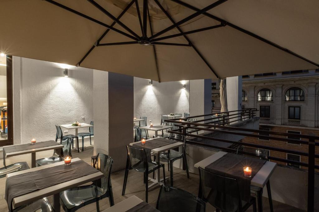 罗马Concept Terrace Hotel的一间带桌椅和遮阳伞的餐厅