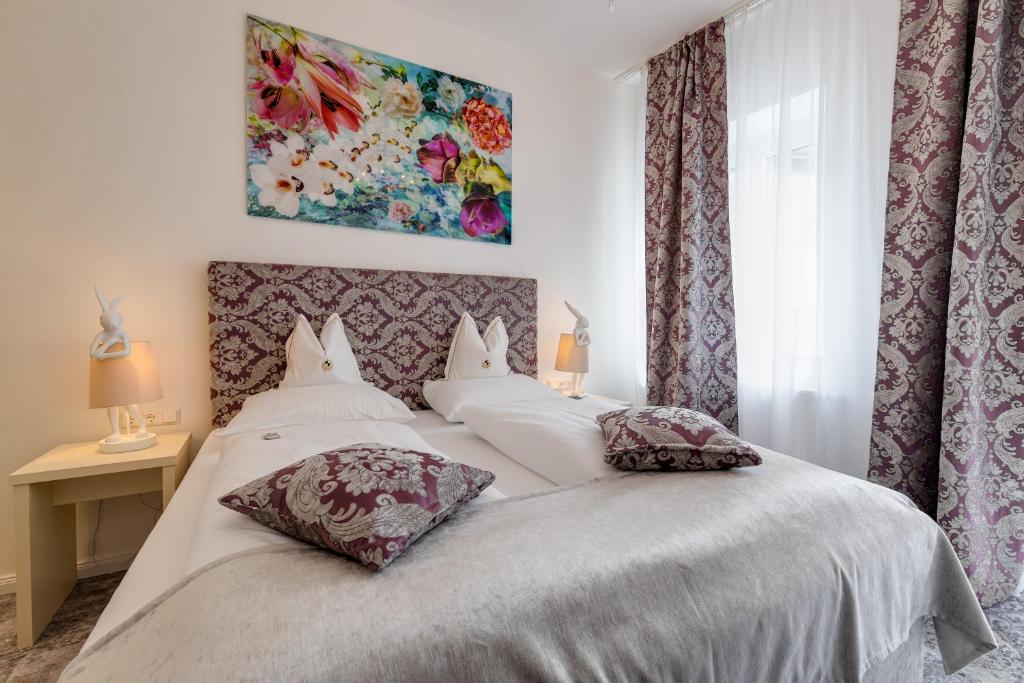 菲拉赫Boutique Hotel Goldenes Lamm的卧室配有白色的床和2个枕头