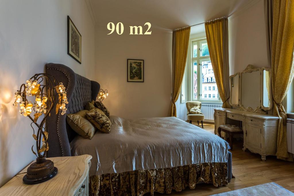 卡罗维发利Karlsbad Prestige的一间卧室配有一张床、一张书桌和一个窗户。