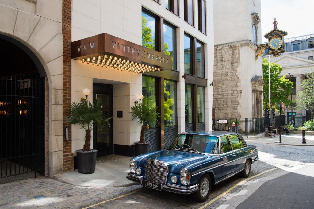 伦敦Vintry & Mercer Hotel - Small Luxury Hotels of the World的停在大楼前的旧蓝色汽车