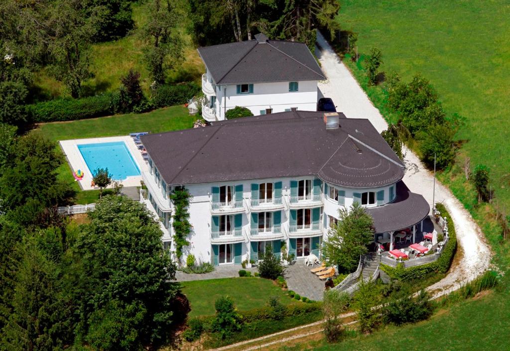 沃尔特湖畔佩莎赫达斯豪普特曼旅馆的享有带游泳池的大型白色房屋的顶部景致