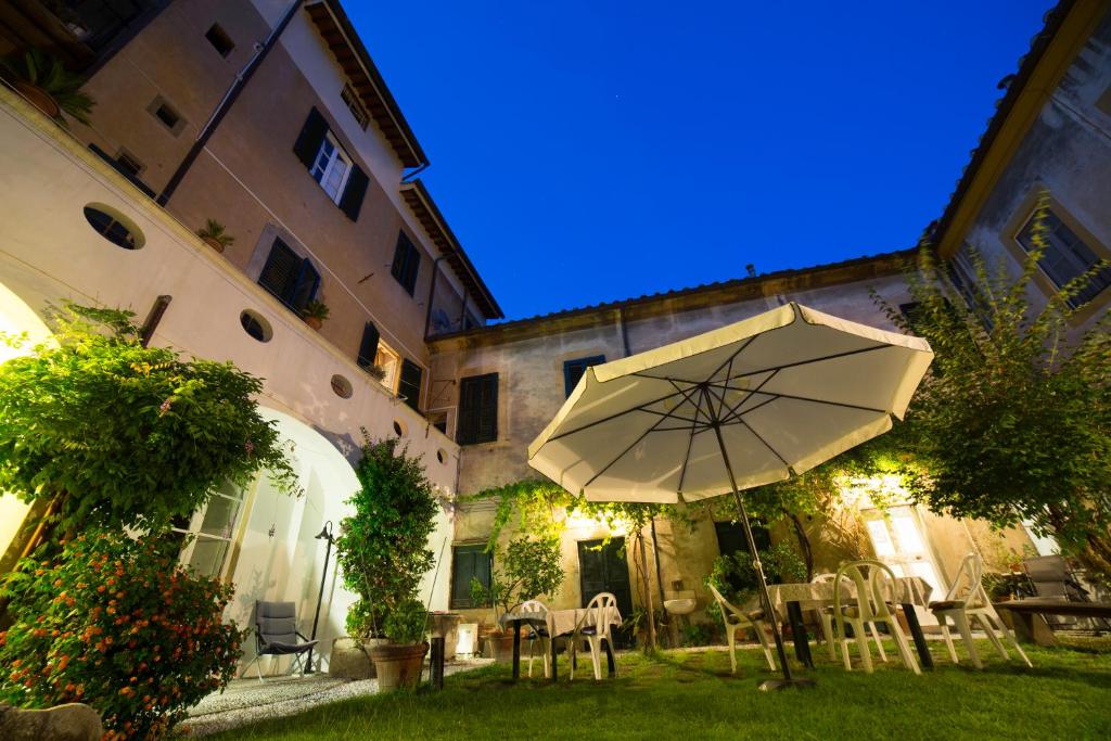 比萨萨塞蒂中继住宿加早餐旅馆的庭院配有遮阳伞和桌椅。
